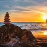 Steinstapel am Strand als Symbol für Balance und Weitblick durch die Anwendung von Intuition im Rahmen der Führungsaufgabe.