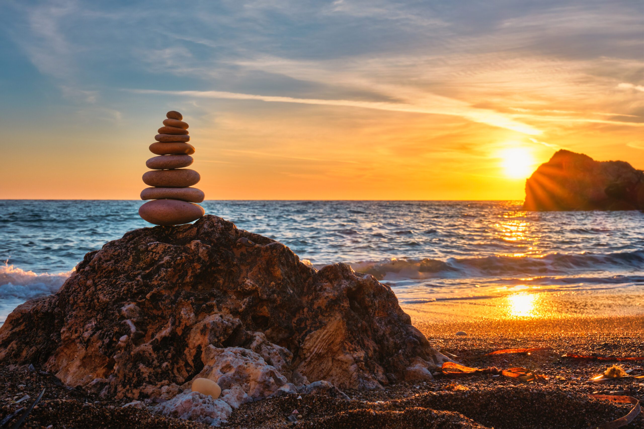 Steinstapel am Strand als Symbol für Balance und Weitblick durch die Anwendung von Intuition im Rahmen der Führungsaufgabe.