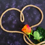 Herz aus Seil mit Rose, als Metapher für die Gefangenschaft in einer toxischen oder narzisstischen Beziehung