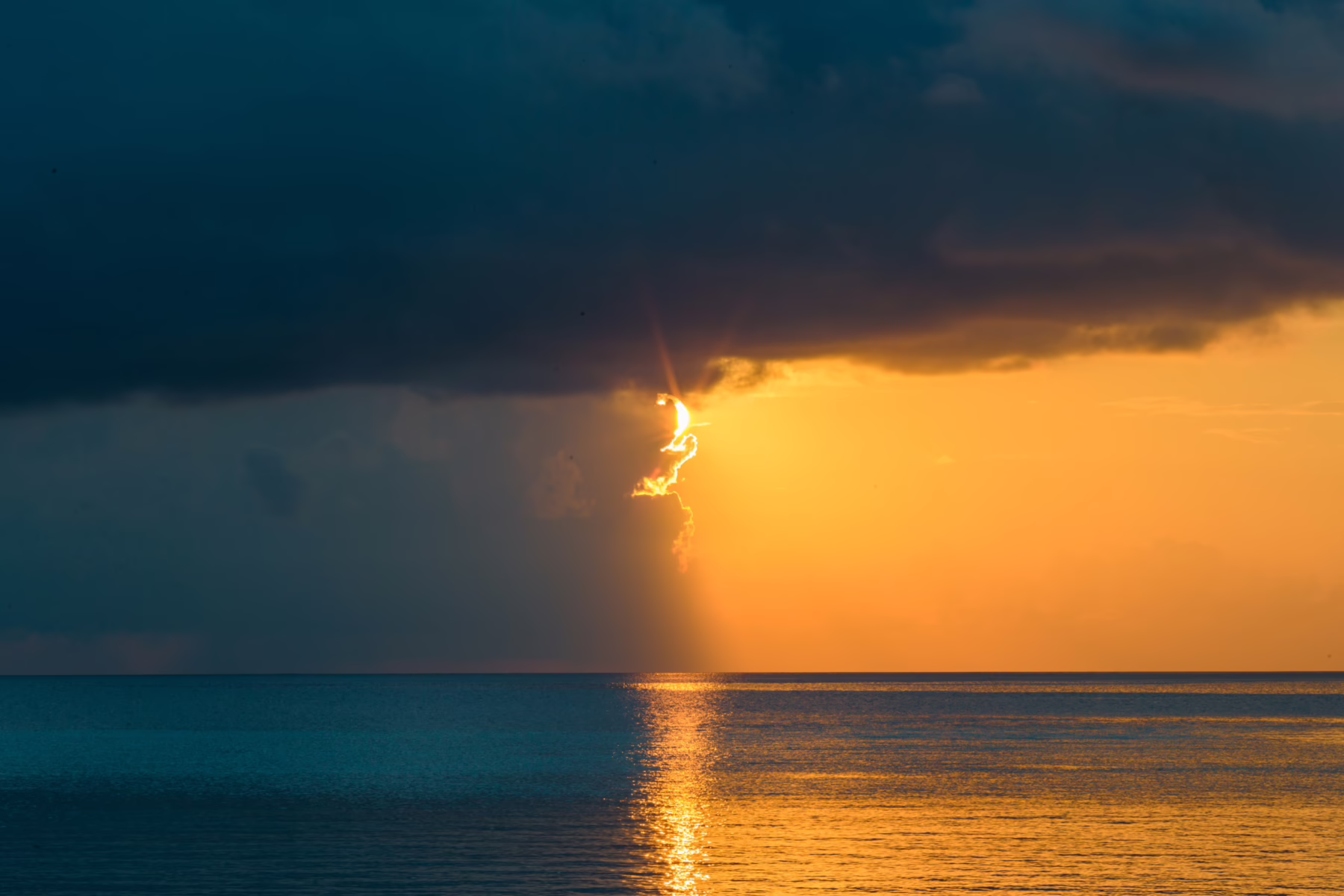 Regenwolken und Sonne über dem Meer. Eine dunkle und eine helle Seite. Eine Metapher für die Integration von Gegensätzen, die zeitgleich bestehen können. Und auch eine Metapher für die Spaltung, die aufgrund der Diagnose mitten durch den Freundeskreis gehen kann