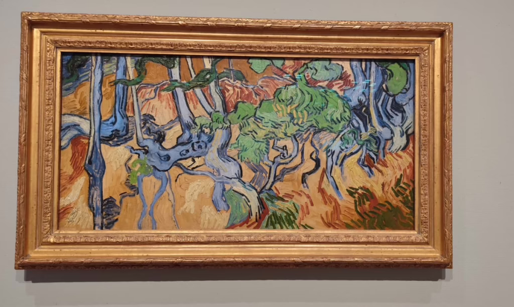 Das letzte Bild von Van Gogh im Goldrahmen vor grauer Wand. Abstrakte Formen, blau, gründ und rot dominieren vor gelbem Hintergrund. Aufgenommen im Van Gogh Museum in Amsterdam im September 2025